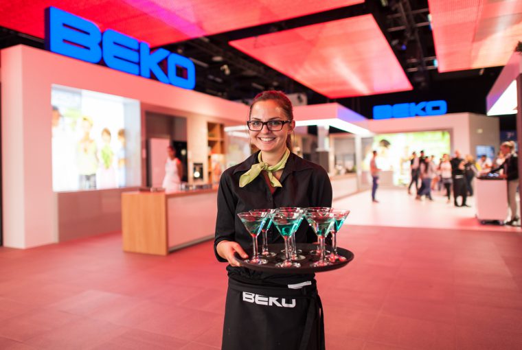 Hostess auf einer Messe fotografiert mit Gläsern